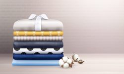 Ironed clothes and colorful linen stack decorated with cotton branch realistic composition vector illustration